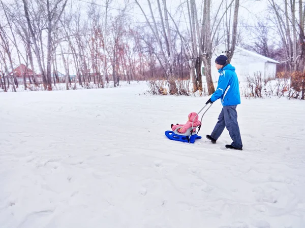 Padre con passeggiata di bambino nell'inverno la slitta su neve . — Foto Stock