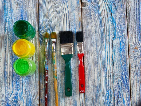 Acrylfarben und farbige Pinsel auf einem authentischen Hintergrund von Hand mit Copyspace gemacht — Stockfoto