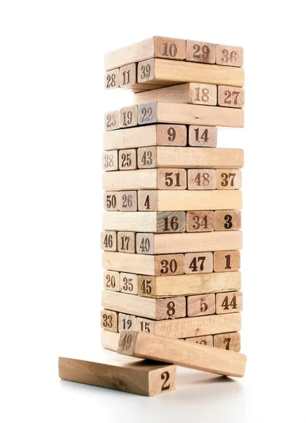 Beyaz arka plan üzerinde izole oyun jenga bloklarını. Dikey kule tüm ve oyunda. Yığın vücut üzerinde haneli rakamlar ile ahşap bloklar.