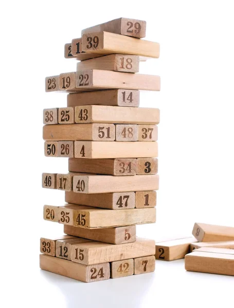 Jenga-Blöcke isoliert auf weißem Hintergrund. senkrechter Turm ganz und im Spiel. Holzblöcke im Stapel mit Ziffern auf dem Körper. — Stockfoto