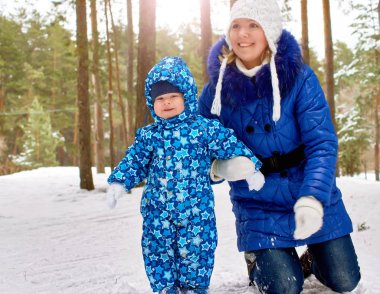 Mutlu ve neşeli anne ve çocuk yürüyüşte, oyun kış ormanda. Çam ormanı, Çelyabinsk, Ural, Rusya Federasyonu. Aile portresi.