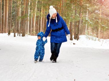 Mutlu ve neşeli anne ve çocuk yürüyüşte, oyun kış ormanda. Çam ormanı, Çelyabinsk, Ural, Rusya Federasyonu. Aile portresi.