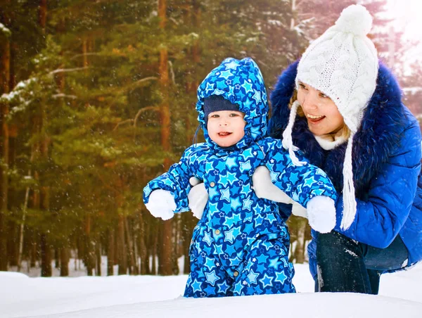 Madre felice e gioiosa e bambino a piedi, giocare nella foresta invernale. Pineta della regione di Chelyabinsk, Ural, Russia. Ritratto di famiglia . — Foto Stock