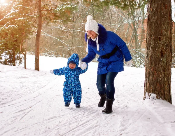 Madre felice e gioiosa e bambino a piedi, giocare nella foresta invernale. Pineta della regione di Chelyabinsk, Ural, Russia. Ritratto di famiglia . — Foto Stock