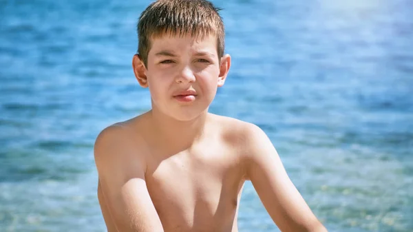 Young beautiful european caucasian boy plays on beach sand pebble sea Montenegro Boka kotorska — Stock Photo, Image