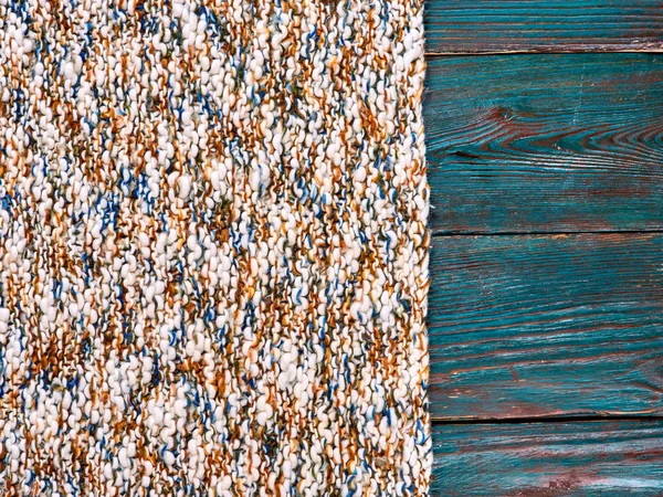 Knitted product carpet plaid close up of fiber of thread texture wool wooden background board floor brown green