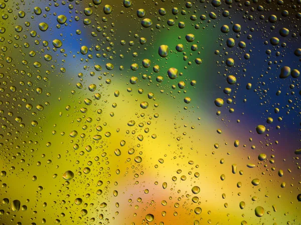 Vatten droppar färg bakgrunden regn glas utrymme rainbow. — Stockfoto