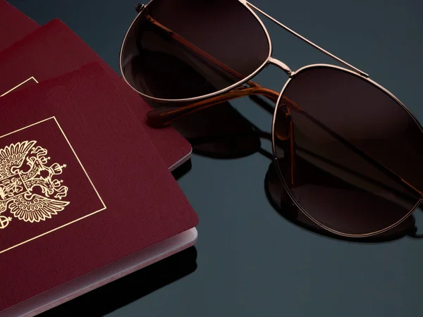 Turisztikai koncepció napszemüveg passport utazás a szürke háttér és a lejtés. — Stock Fotó