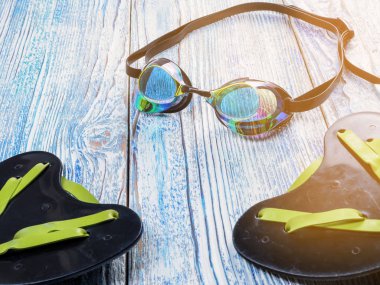 Ahşap arka plan güneş ışığında yüzme spor için aksesuarlar.