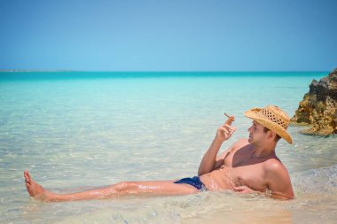 Mutlu başarılı yakışıklı adam Cayo Guillermo plajda, Atlantik Okyanusu, Küba, Playa Pilar, puro ile.