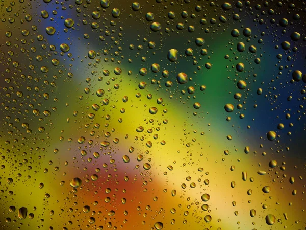 Gotas de água cor fundo chuva vidro espaço arco-íris . — Fotografia de Stock