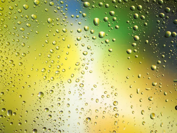Barva pozadí déšť sklo prostoru rainbow kapky vody. — Stock fotografie