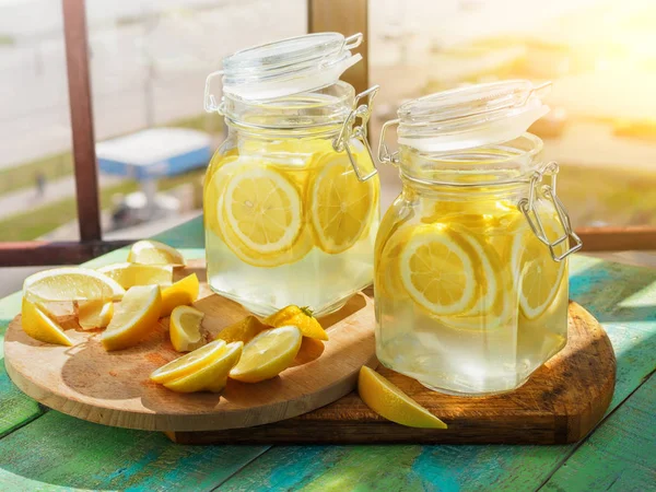 Kolde Lemonade is, i kander, halm, byudsigt - Stock-foto
