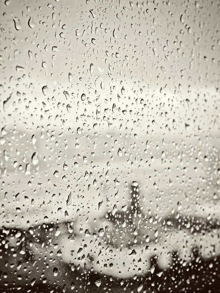 Regen in der Stadt, Wassertropfen auf nasses Fensterglas, Sonnenuntergang — Stockfoto