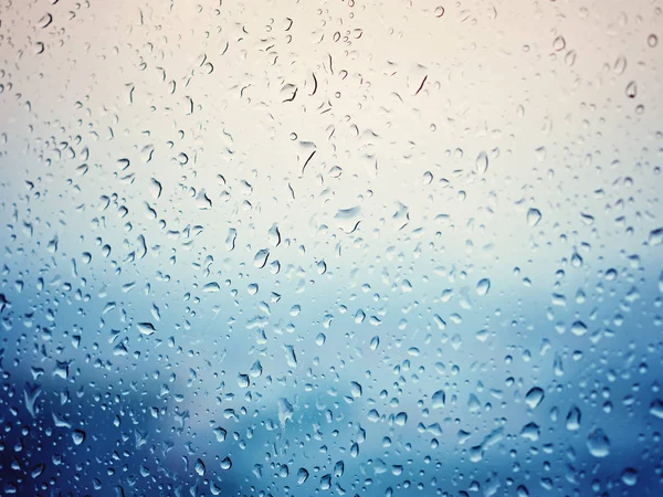 Rain in city, water drops on wet window glass