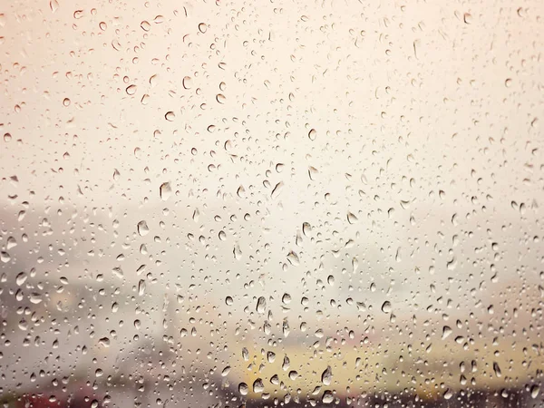 Regn i byen, vanddråber på vådt vinduesglas, solnedgang - Stock-foto