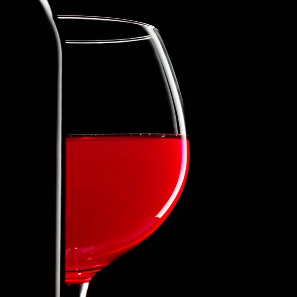 Garrafa de silhueta elegante de vinho tinto e vidro sobre fundo preto — Fotografia de Stock