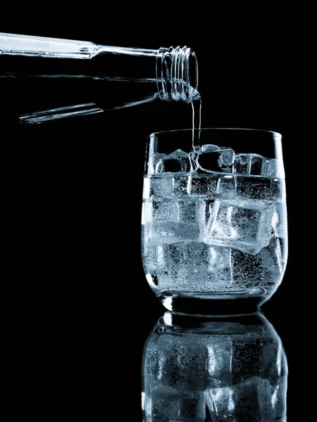 Bottiglia di acqua minerale di soda versata nel vetro — Foto Stock