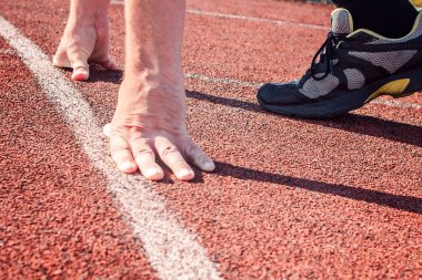 Çalıştırıcısı başlangıç konumu'nda. Başlangıç çizgisine ellerde.