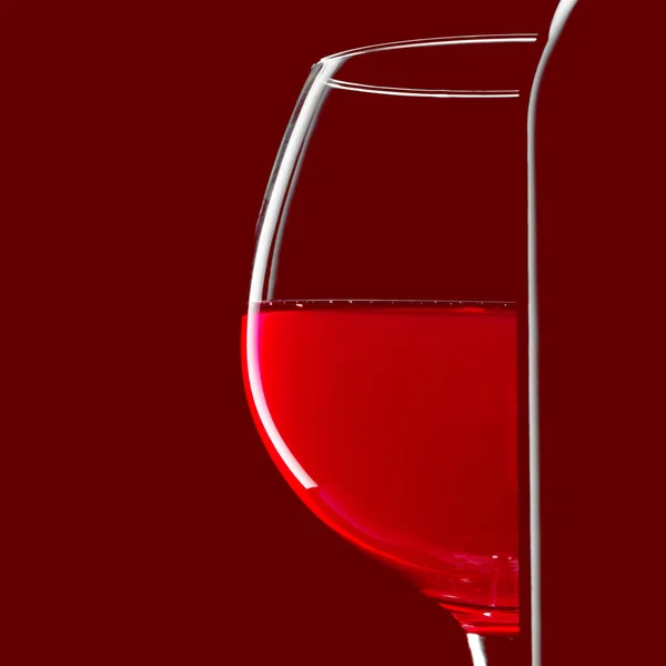 Garrafa de silhueta elegante de vinho tinto e vidro sobre fundo preto — Fotografia de Stock