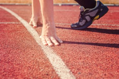 Çalıştırıcısı başlangıç konumu'nda. Başlangıç çizgisine ellerde.