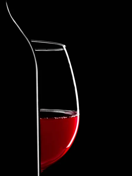 Garrafa de silhueta elegante de vinho tinto e vidro sobre fundo preto — Fotografia de Stock