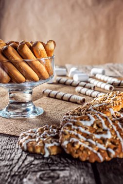 Natürmort tarifi ev yapımı tatlım zencefil yulaf ezmesi kurabiye, tek ayak üzerinde dönüş rulo gofret ve tahıl ahşap masa mutfak üzerinde sopa