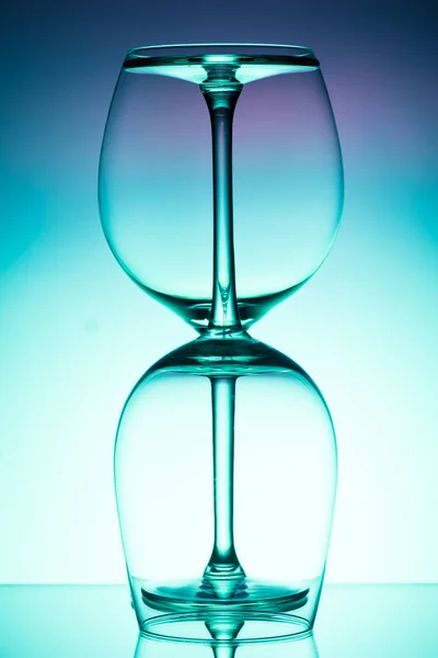 Dois copo de vinho vazio para vinho tinto sobre fundo iluminado difusão em abstrato — Fotografia de Stock