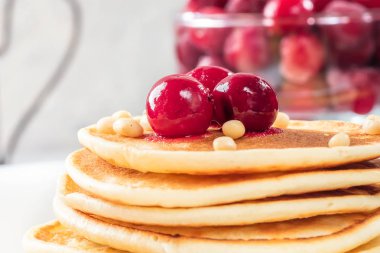 Ev yapımı kek kiraz ve çam fıstığı beyaz tabakta Dondurulmuş çilek ile dekore edilmiş yığın krep