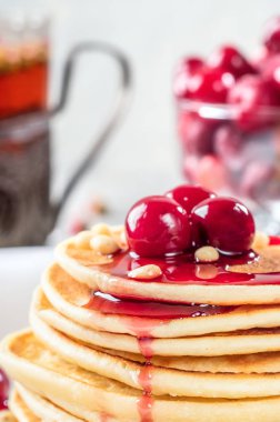 Ev yapımı kek kiraz ve çam fıstığı beyaz tabakta Dondurulmuş çilek ile dekore edilmiş yığın krep