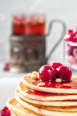 Ev yapımı kek kiraz ve çam fıstığı beyaz tabakta Dondurulmuş çilek ile dekore edilmiş yığın krep