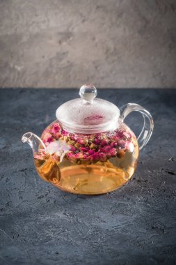 Çiçek tomurcuklu kuru kırmızı pembe Gül çay yoğuşma sıcak su buhar damlaları ile Detoks içkiyle çaydanlık