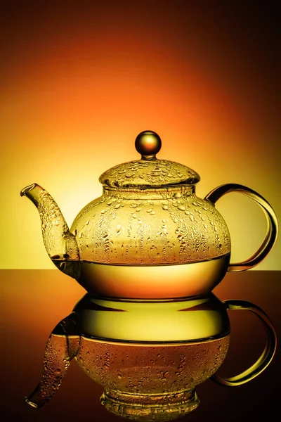 Glass teapot with boiling water and drops of condensation