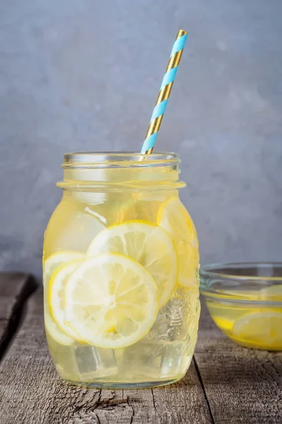 Koktejlové sklenice limonády a ledové kostky drobky na pozadí dřevěný stůl — Stock fotografie