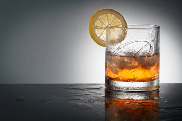 Çelyabinsk, Rusya Federasyonu - Nisan Dambarton, İskoçya Pernod Ri tarafından üretilen cam, en iyi harmanlanmış Scotch viski Ballantines logosu ile doğal buz küpleri ve bir dilim limon vuruşta arka plan Delicious Scotch Whisky Ballantines reklam 10,2018