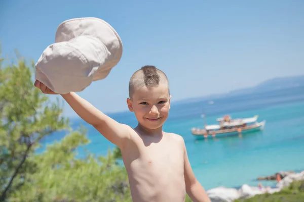 Chłopiec macha kapelusz Sea Shore — Zdjęcie stockowe
