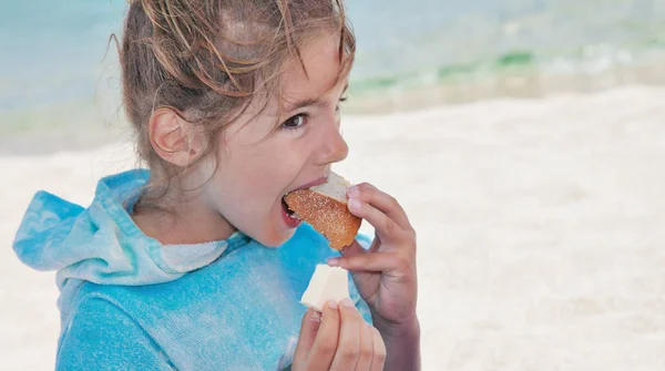Dziewczyna dziecko jedzenie plaża chleb — Zdjęcie stockowe