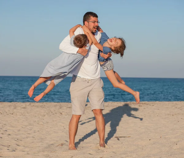 Giostra padre bambini spiaggia — Foto Stock