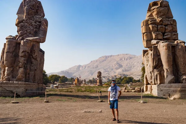 Man in de buurt van de ruïnes van standbeelden in Luxor, Egypte — Stockfoto