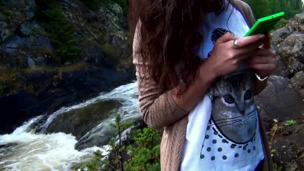 Молодая женщина перед водопадом — стоковое видео