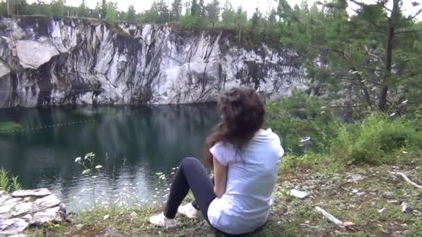 Woman sitting alone by a river — Stock Video