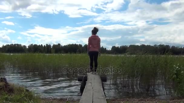 Женщина, стоящая на пристани — стоковое видео