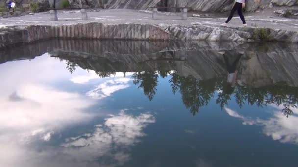 Spiegelbild einer wandelnden Frau auf dem Wasser — Stockvideo