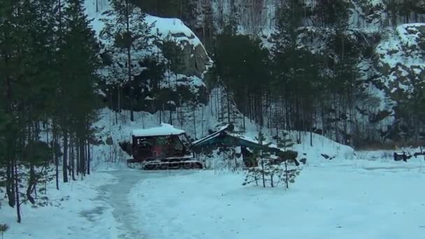 Старый трактор в заброшенном промышленном комплексе зимой — стоковое видео