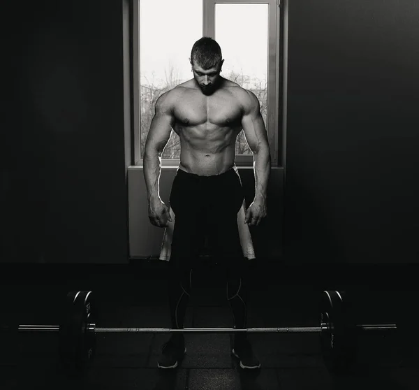 bekleyen ve ağır halter kaldırma önce hazırlanıyor Avrupa beyaz atletik bir adam. Fitness, spor, eğitim, spor salonunda poz. Deadlift ile Halter. Halter Bent. siyah ve beyaz