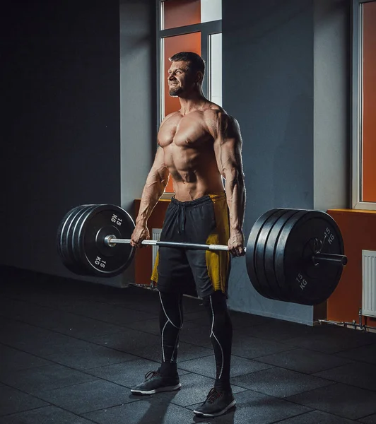 Deadlift ile ağır halter yapan Avrupa beyaz atletik erkek. adam halter kaldırma pencere karşısında. ağırlık kaldırma duygusal anlar yaşanıyor. duygusal içinde jimnastik salonu kaldırma. spor salonunda poz