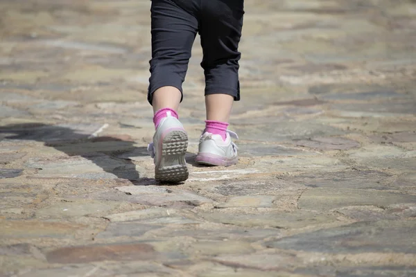 Αγνώριστος παιδί μακριά περπατώντας στο πέτρινο μονοπάτι — Φωτογραφία Αρχείου
