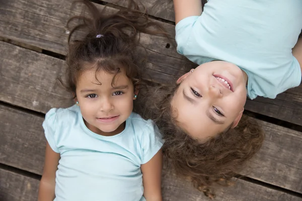 Schöne Kinder in blauen T-Shirts auf Holzboden — Stockfoto