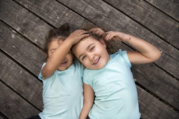 Två glada lilla barn på trägolv — Stockfoto