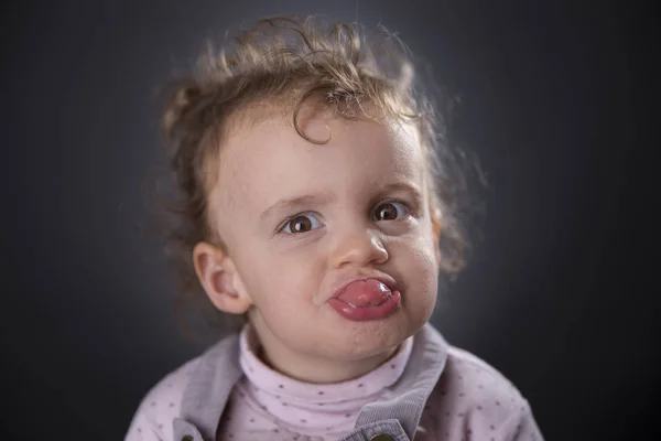 Två år tjej sticker ut tungan — Stockfoto